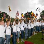 Local school children sing national anthems